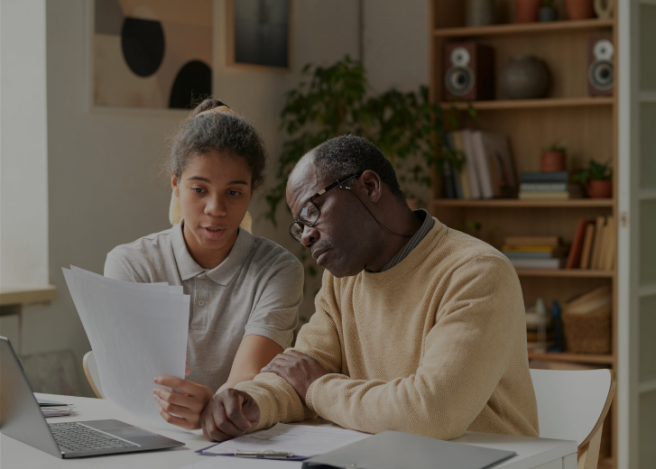 man and girl reviewing paperwork at home